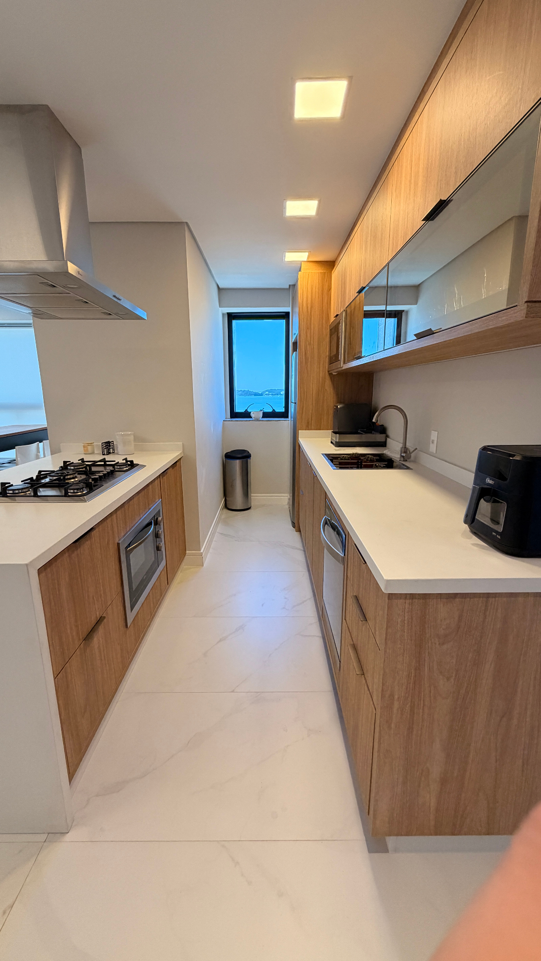 Cozinha gourmet com bancada em quartzo branco e vista mar